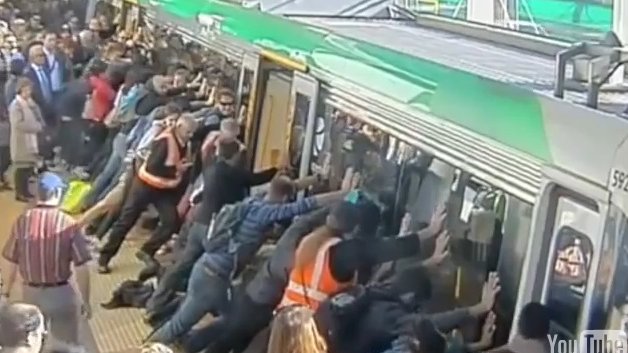 Decenas de personas mueven un tren para salvar a un hombre